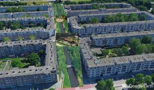 Aerial photo of the housing blocks with a rendered canal and green corridor drawn over one of the streets.